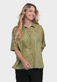 Short-sleeve, button-up shirt in olive green, made of soft linen. Features a collar and a subtle triangular logo on the chest.