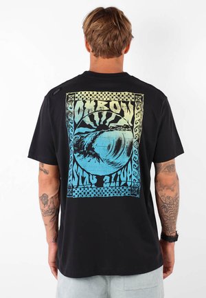 T-shirt noir à manches courtes avec un design graphique bleu de vagues et du texte au dos, bordé de carreaux et avec des accents tribaux.