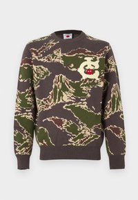 Καφέ, πράσινο και εκρού πλεκτό πουλόβερ παραλλαγής με στρογγυλή λαιμόκοψη και σχέδιο κόκκινης κερασιάς στο μπροστινό μέρος.