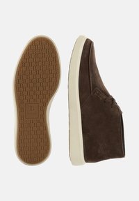 Zapatilla de ante marrón con cordones y suela blanca, vista lateral y patrón de la suela con el logo en relieve de Boggi Milano.