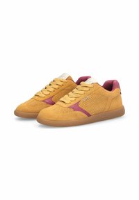 Paire de baskets en daim jaune moutarde avec détails perforés, lacets beiges et accents bordeaux sur les côtés et la doublure, présentées sur fond blanc.