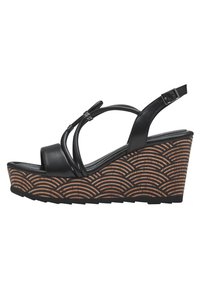 Black wedge sandals with cross straps, featuring a textured brown platform with wave patterns and an adjustable ankle strap.
