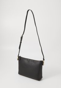 Schwarze Leder-Shoppingtasche mit strukturierter Oberfläche, Reißverschluss und verstellbarem Riemen. Akzente aus goldfarbenem Metall, minimalistisches Design.
