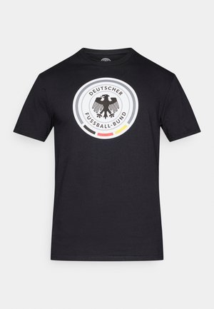 Μαύρο βαμβακερό μπλουζάκι με κυκλικό γραφικό που απεικονίζει το λογότυπο της Γερμανικής Ποδοσφαιρικής Ομοσπονδίας, με λευκές, κόκκινες και κίτρινες λεπτομέρειες.