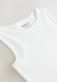 Weißes geripptes Tanktop mit rundem Ausschnitt und breiten Trägern. Innen sichtbar ist das Etikett mit Markeninformationen.