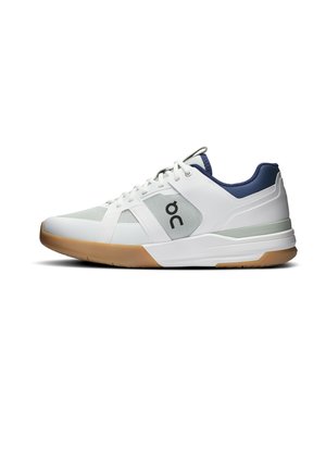 Weißer und grauer Sportschuh mit Gummisohle, marineblauem Kragen, weißen Schnürsenkeln und schwarzem „on“-Logo an der Seite, gezeigt in rechter Seitenansicht.