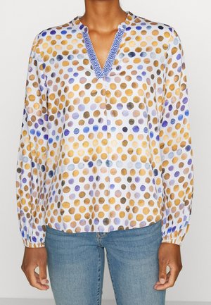 Blouse à manches longues avec des pois de style aquarelle en or, bleu et violet, présentant un décolleté en V à motifs bleus et des poignets élastiques.