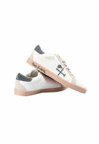 Witte sneakers met een grijze suède hiel en beige accenten, voorzien van "HARPER" geperst aan de zijkant en grafische details aan de buitenkant.