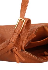 Bruine leren handtas met een structuurafwerking, voorzien van goudkleurige hardware, een ritssluiting en een verstelbare schouderband. Interieurlzakken zichtbaar.