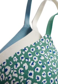Tři podprsenky s různými designy: jedna jednobarevná mátově zelená, jedna jednobarevná světle modrá a jedna s leopardím potiskem v zelené, bílé a modré barvě.