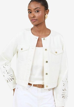 Weiße Denimjacke mit rundem Halsausschnitt, Druckknöpfen, Brusttaschen und laserbeschnittenen Blumenmustern an den Ärmeln.