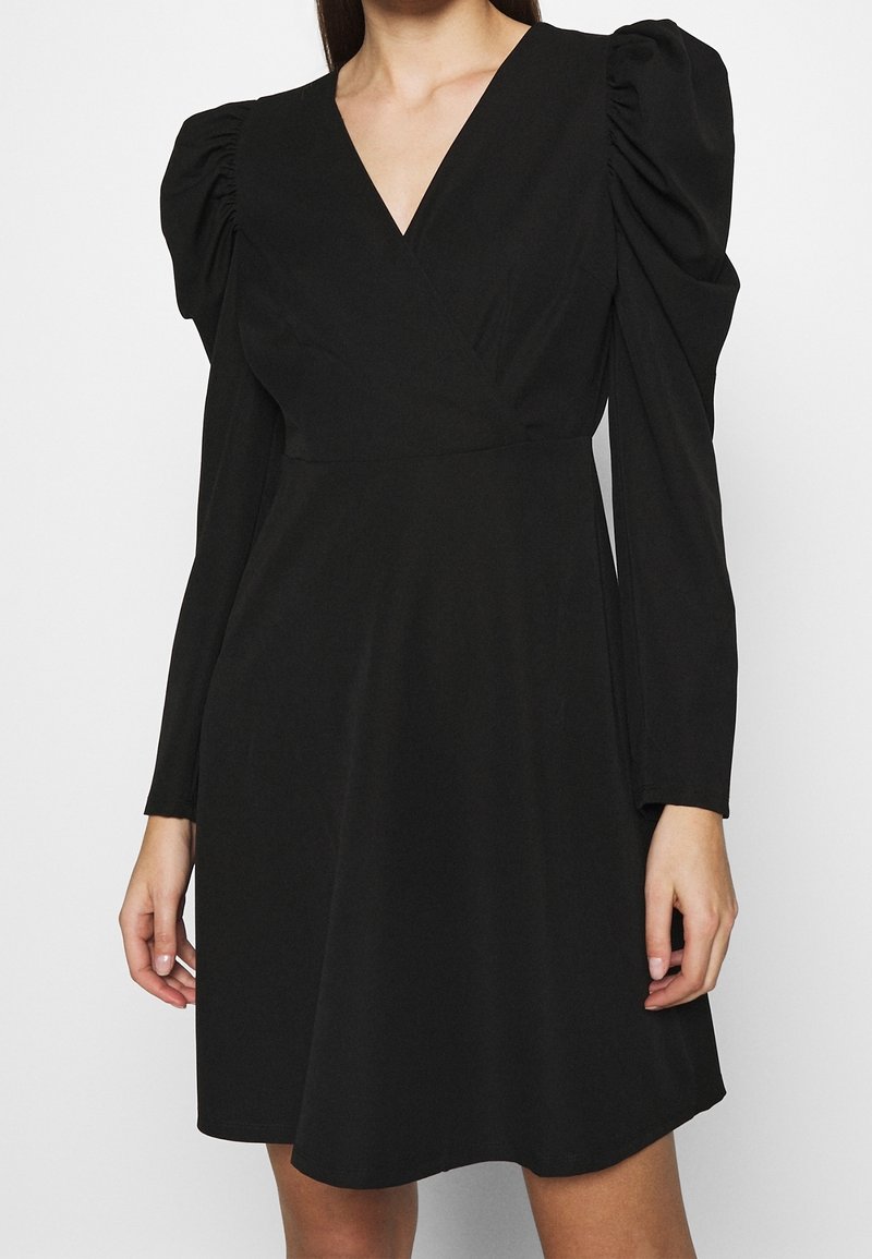 Schwarzes Wickelkleid mit langen Ärmeln und ballonartigen Schultern, mit V-Ausschnitt und glattem Stoff sowie fließender Silhouette.