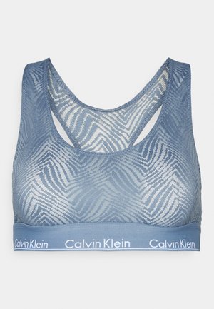 Light blue sports bra with a textured zigzag pattern, featuring a racerback design and a wide band with "Calvin Klein" branding.