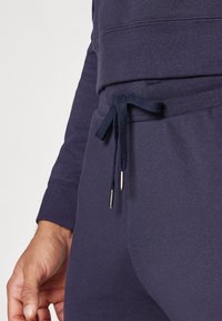 Marineblauwe katoenen sweatshirt met een ronde halslijn en geribde manchetten, voorzien van een trekkoord in de taille en metalen uiteinden op de veters.