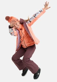 Outfit invernale per ragazzi composto da una giacca arancione e viola, strato interno arancione con texture, pantaloni marroni e stivali da neve neri con suole bianche.