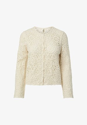 Cardigan en crochet crème à manches longues avec des motifs floraux et des boutons recouverts de tissu sur le devant.