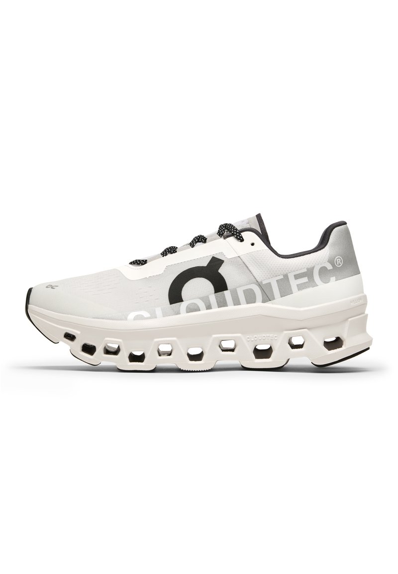 Zapatilla de running blanca con parte superior de malla, acentos negros, suela acolchada con recortes hexagonales y marca "CLOUDTEC".