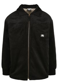 Zwart corduroy jack met een ritssluiting aan de voorkant, twee borstzakken, ribbelstructuur en een luxe voering, met een klein logopatch op de borst.