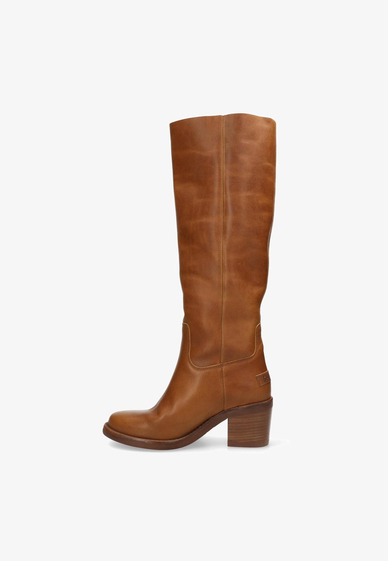 Botas de cuero marrón hasta la rodilla con punta redondeada, tacón bajo, detalles de costura y un parche con logo en el lateral. Textura suave y pulida.