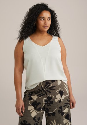 Light green sleeveless top with a V-neck and a relaxed fit, paired with patterned wide-leg pants featuring black and cream floral designs.