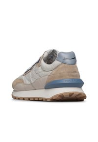 Sneakers da uomo con una tomaia in suede e pelle crema e beige, tallone con dettagli blu, intersuola bianca e suola in gomma testurizzata.