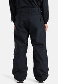 Melni ūdensizturīgi sniega bikses ar vaļīgu piegriezumu, ar teksturētu virsmu un regulējamu jostasvietu. Iekļauj aizmugurējās kabatas un pastiprinātas apakšmalas.