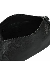 Schwarze Lederhandtasche mit strukturiertem Äußeren, Reißverschluss und einer Innentasche mit glattem Stofffutter.