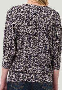 Pullover-Top mit Leopardenmuster in Grautönen und Schwarz, mit Dreiviertelärmeln und lockerer Passform. Weicher, strukturierter Stoff mit geripptem Saum.
