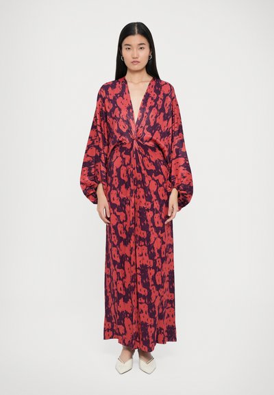 Robe longue et fluide en imprimé abstrait rouge et bleu marine, avec un décolleté en V profond et des manches volumineuses. Tissu doux avec une texture lisse.