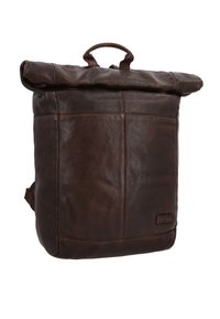Bruine leren rugzak met een opgerolde bovenkant, voorzien van een klein handvat, een gestructureerd oppervlak en een zijvak. Eenvoudige stiksels en logo-detail zichtbaar.