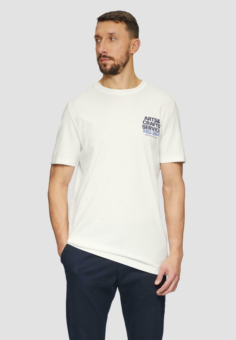 Witte T-shirt met korte mouwen van katoen, met blauwe tekst op de linkerkant van de borst die "ARTS & CRAFTS SERVICE 9302-3090" zegt.