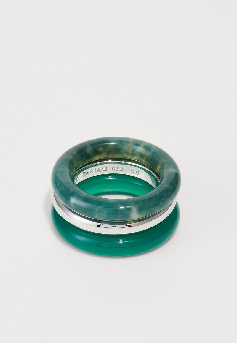 Ineluri suprapuse cu un detaliu din rășină verde translucidă, un inel solid din rășină verde și un accent din metal argintiu între ele.