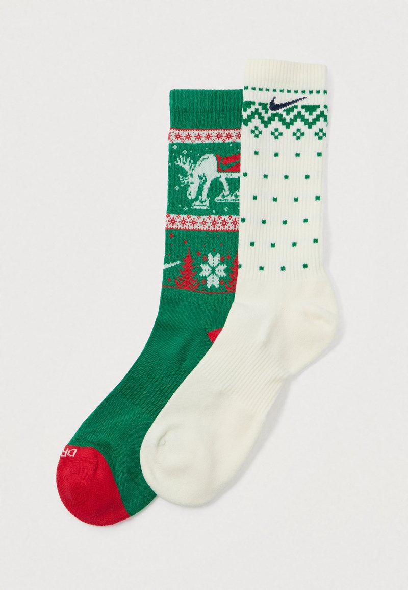 En grønn julesokk med rød hæl og hvite snøfnugg, sammen med en hvit sokk med grønne mønstre og et Nike-logo.