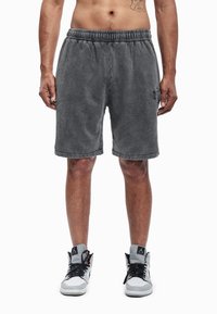 Pilkos medvilninės trumpikės su elastinga juosmens juosta ir šonine kišene, kairėje kojinėje subtiliai įspaustas logotipas bei minkštas, tekstūruotas paviršius.