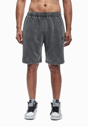 Shorts de algodón gris con cinturilla elástica y bolsillo lateral, con un logo sutil en la pierna izquierda y un acabado suave y texturizado.