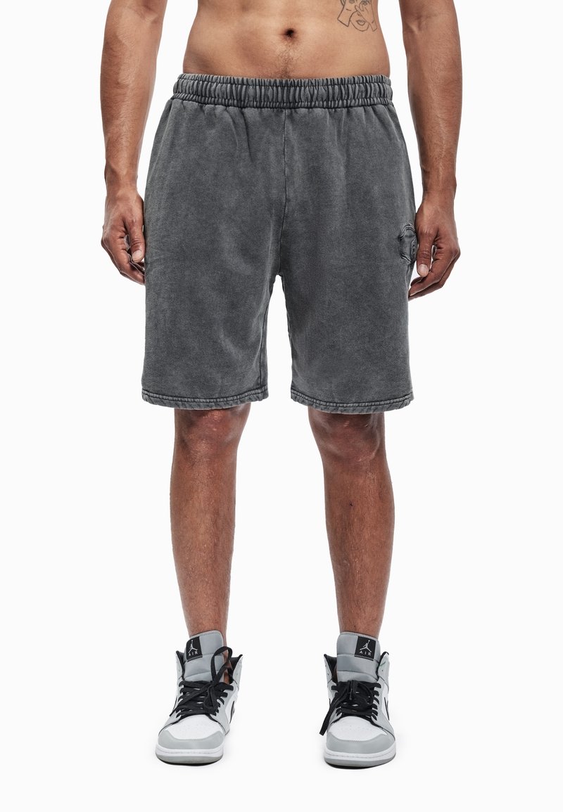 Pilkos medvilninės trumpikės su elastinga juosmens juosta ir šonine kišene, kairėje kojinėje subtiliai įspaustas logotipas bei minkštas, tekstūruotas paviršius.