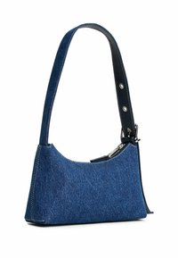 Denim schoudertas met een gebogen vorm, donkerblauwe kleur, en leren schouderriem met metalen accenten en witte stikdetails.