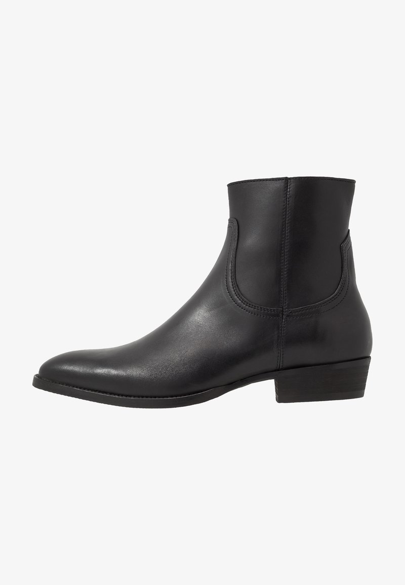 Bottine en cuir noir avec talon bloc bas, bout arrondi et détail de couture latérale, vue de côté extérieur sur fond blanc.