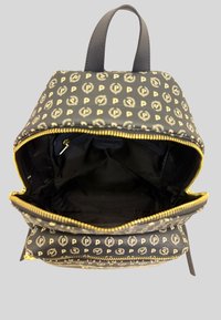 Czarny plecak z tkaniny z złotym zamkiem, z powtarzającym się wzorem logo. Wnętrze ma ciemne podszewkę z jedną kieszenią na zamek. Dwa uchwyty na górze.
