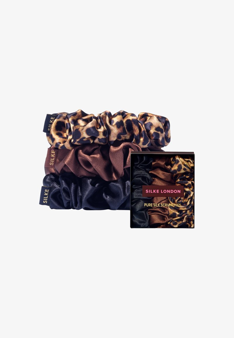 Set med tre silkescrunchies i leopardmönster, rik brun och djup marinblå färg. Förpackad i en svart låda med röda accenter.
