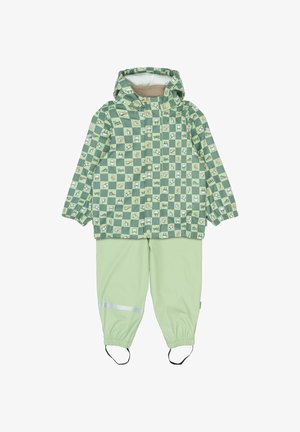 Groene geruite regenjas met capuchon, met diverse kleine patronen, gecombineerd met bijpassende lichtgroene broek en reflecterende accenten.