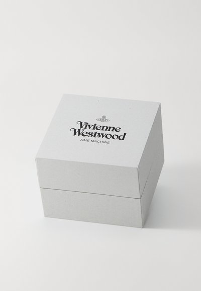 Caixa de cartão cinza com tapa, apresentando texto preto, "Vivienne Westwood TIME MACHINE," centrado no topo. Design simples, formato quadrado.