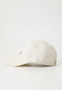 Căciulă de baseball bej, fabricată din bumbac, cu logo-uri brodate pe față și pe lateral, curea ajustabilă la spate și vizieră curved.