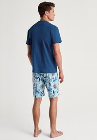 Heren blauwe t-shirt en gemusterd lichtblauw short met zon- en maanontwerpen, gemaakt van lichte stof, geschikt voor casual draag.