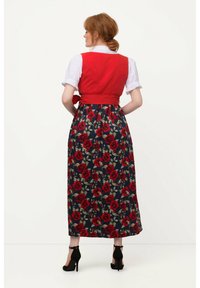 Röd kropp med midjeband, vita puffärmar och en lång marinblå kjol med röd rosblommig tryck. Svarta klackar fulländar looken.