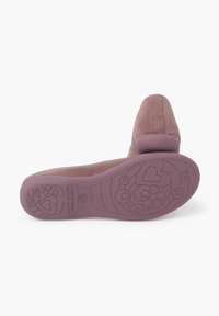Scarpa in suede di un rosa tenue con punta arrotondata e tacco basso. La suola presenta un motivo decorativo con cuori e fiori.