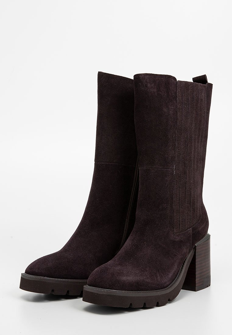 Zamszowe botki za kostkę w głębokim purpurowym kolorze, z masywnym obcasem, żebrowanymi bocznymi panelami i wzmocnionym noskiem. Gładka faktura o matowym wykończeniu.