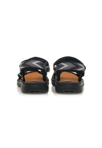 Sandalias negras con correas texturizadas que presentan un patrón geométrico en azul y beige. Suelas de goma con una plantilla acolchada en marrón.