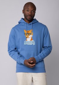 Blauer Hoodie aus Stoff mit einem orangefarbenen Fuchs mit Brille und einem Design eines gestreiften Hemdes auf der Vorderseite. Kängurutasche auf Taillenhöhe.