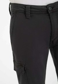 Zwarte cargo-broek van lichtgewicht stof, met knoopsluiting, een voorzak en een zijvak voor extra functionaliteit.